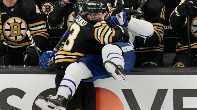 Boston Bruins left wing Brad Marchand (63) checks Toronto Maple...