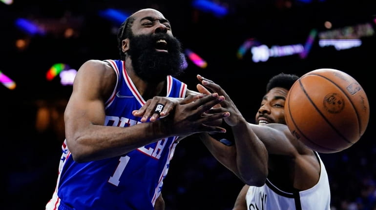 The 76ers' James Harden, left, tries to get a shot...