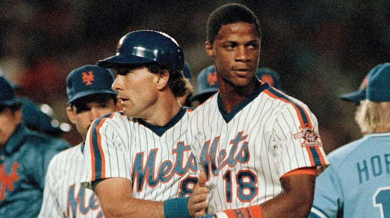 Mets catcher Gary Carter, left, escorts teammate Darryl Strawberry (18)...