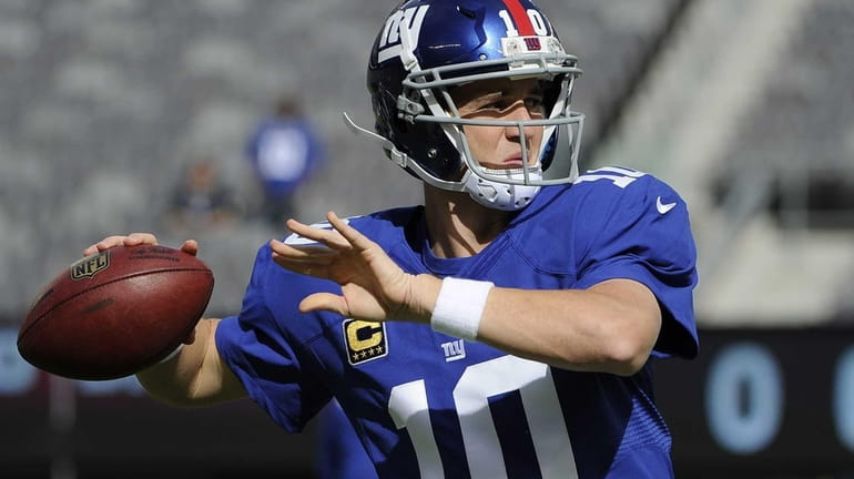 Giants quarterback Eli Manning warms up before action against the...