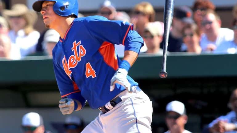 Mets' Wilmer Flores tosses his bat as he heads for...