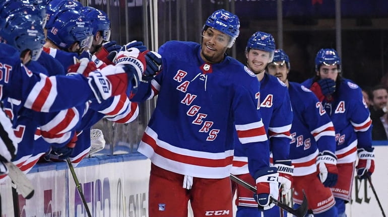 Rangers defenseman K'Andre Miller is congratulated by teammates after he...