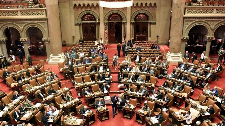 Assembly members vote on Bills in the Assembly chamber at...