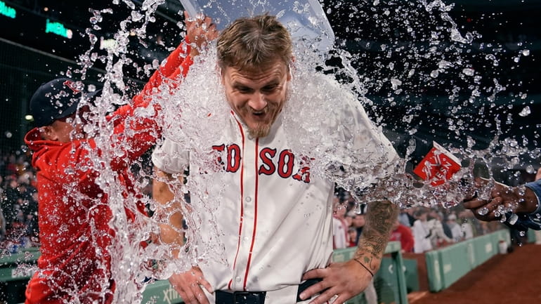 Boston Red Sox pitcher Tanner Houck is doused after throwing...