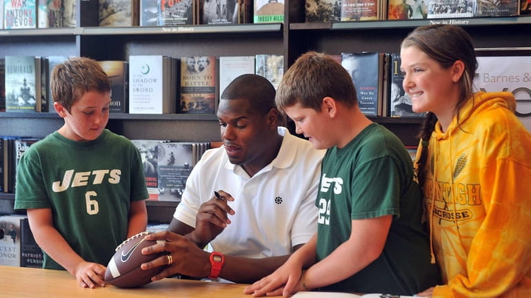 Jets offensive tackle D'Brickashaw Ferguson, second from left, signs a...