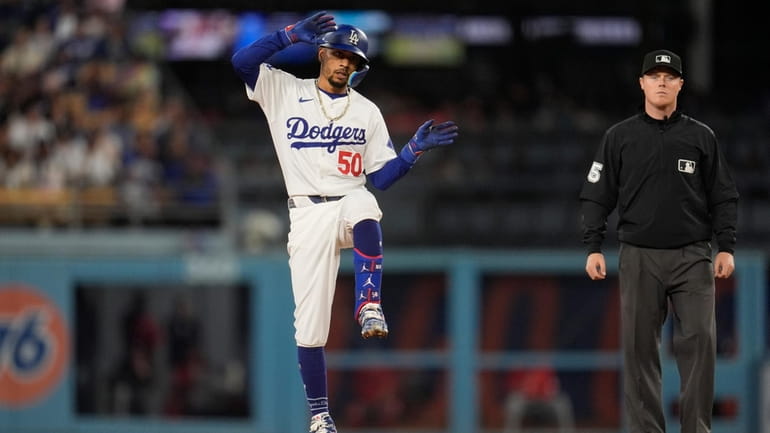 Los Angeles Dodgers' Mookie Betts reacts after driving in a...