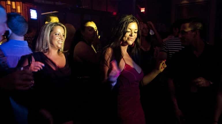 Two friends dance to the music and lights at the...