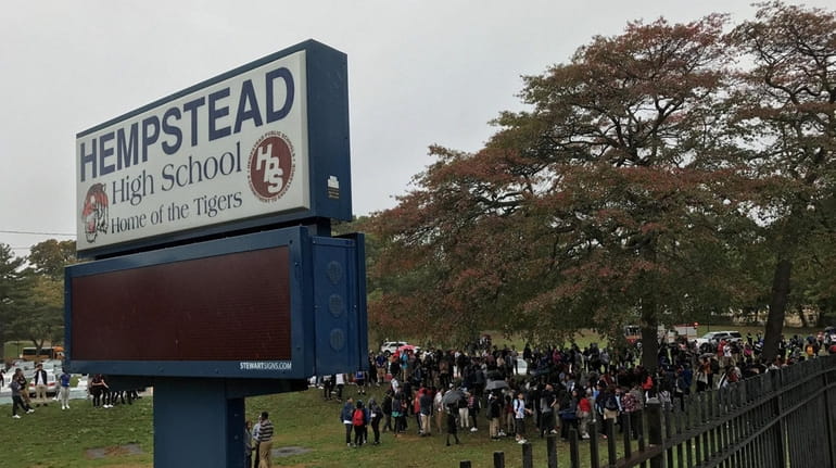 Students stand outside Hempstead High School after they were evacuated...