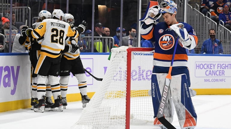Pittsburgh Penguins players celebrate a goal as New York Islanders...