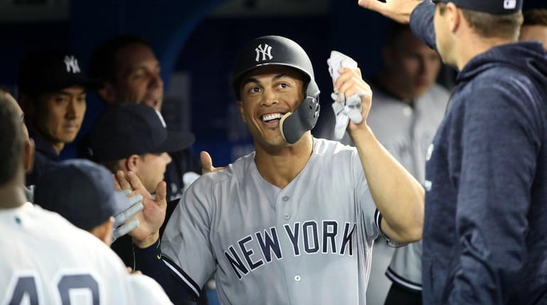 Giancarlo Stanton #27 of the New York Yankees is congratulated...