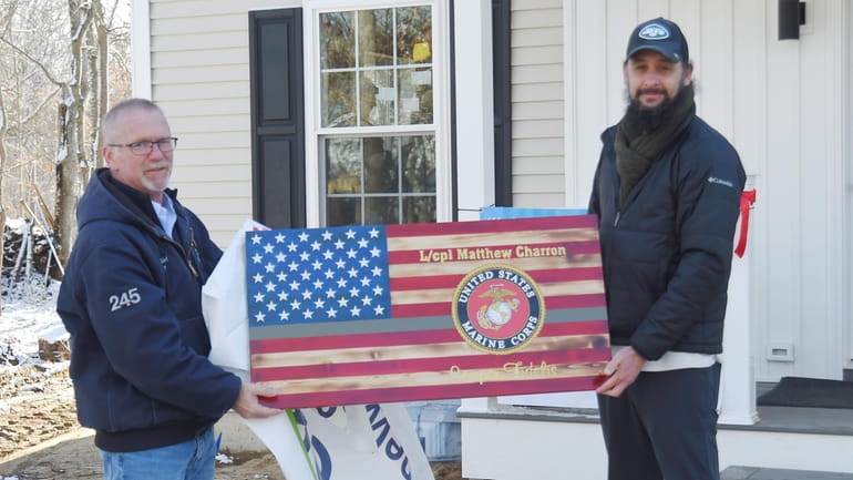 Marine veteran Matthew Charron, right, is presented with a wooden flag...