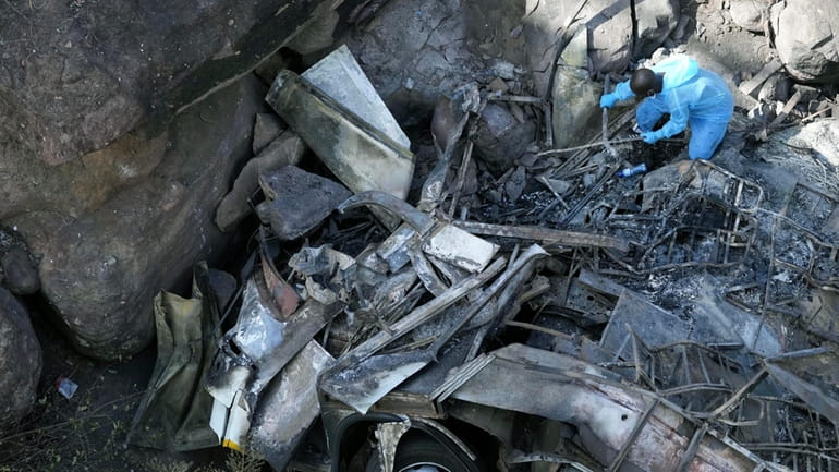 The wreckage off a bus lays in a ravine a...