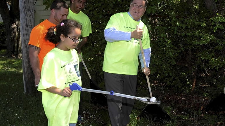 Supervisor Ed Romaine and Cindi Gillette, 10, join other volunteers...