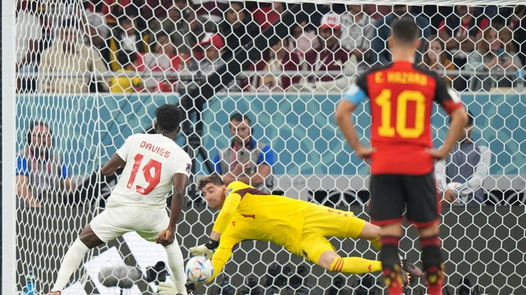 Belgium goalkeeper Thibaut Courtois makes a save on a penalty...