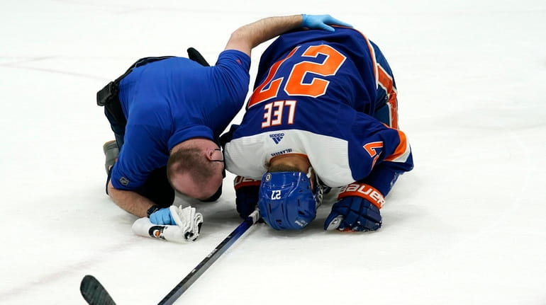 A trainer tends to Islanders left wing Anders Lee, who...