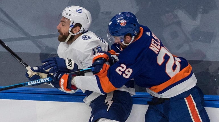 Lightning left wing Barclay Goodrow is checked by Islanders center Brock Nelson during...