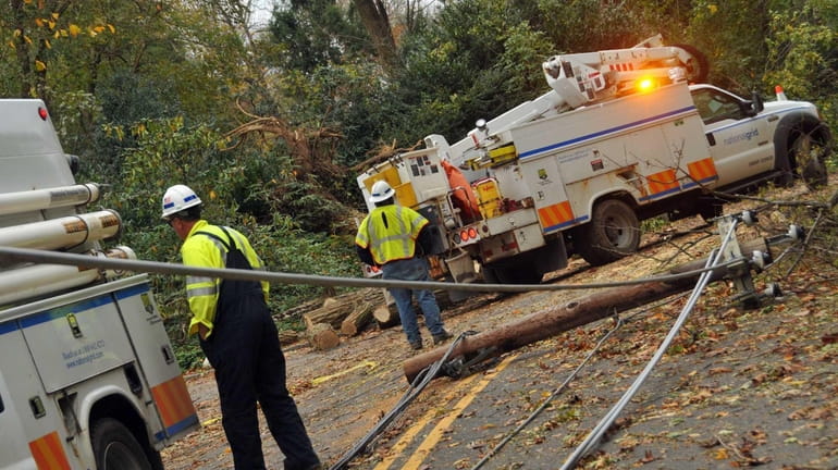 National Grid workers assess roads in Lattingtown for clearing so...