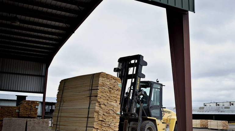 A stack of bass wood lumber is moved with a...
