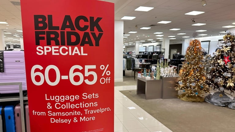 A sign announces Black Friday specials on luggage sets inside...
