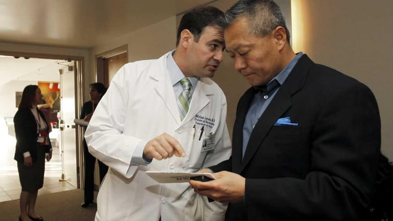 Dr. Michael Lemole, left, Chief of Neurosurgery, confers with Dr....
