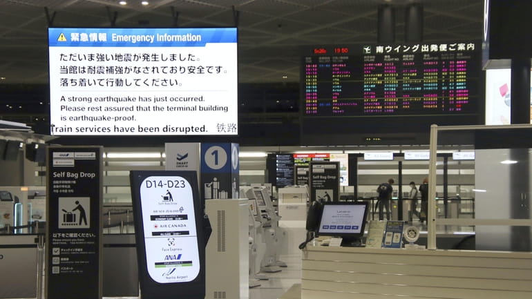 An electronic message board, upper left, at Narita International Airport...
