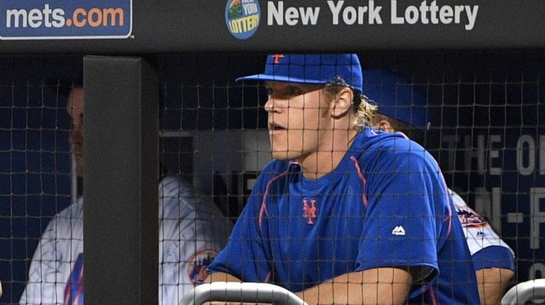 Mets pitcher Noah Syndergaard looks on from the dugout before...