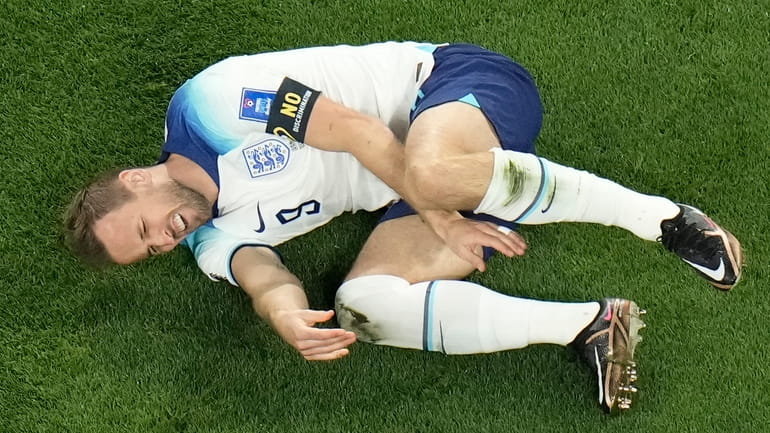 England's Harry Kane grimaces in pain after a tackle by...