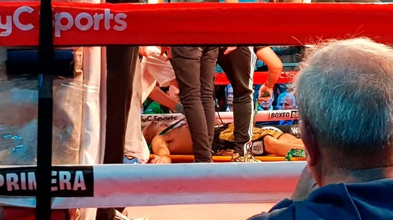 Argentine boxer Hugo Santillan is placed on a stretcher after...