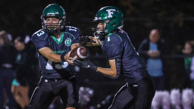 Farmingdale quarterback Anthony Licci hands off to Tomaso Ramos during...