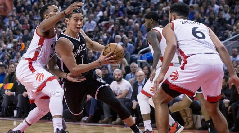 Nets guard Jeremy Lin, center, drives between Toronto Raptors guard...