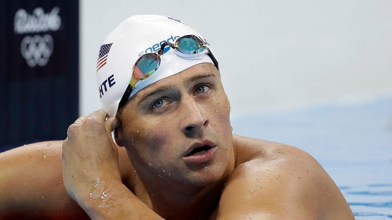 United States' Ryan Lochte checks his time in a men's...