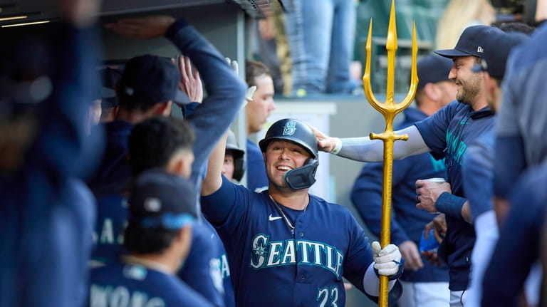 Seattle Mariners' Ty France celebrates in the dugout after his...
