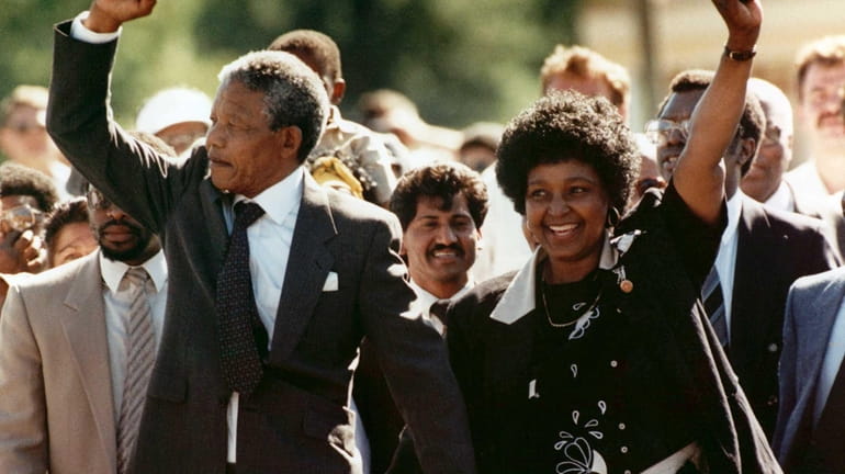 Nelson Mandela and his wife, Winnie, raise clenched fists as...