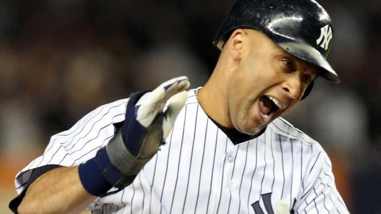 Derek Jeter celebrates after being brought home to score on...