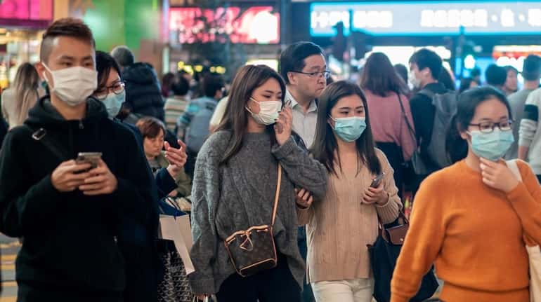 Pedestrians wear face masks to prevent spread of the coronavirus in...
