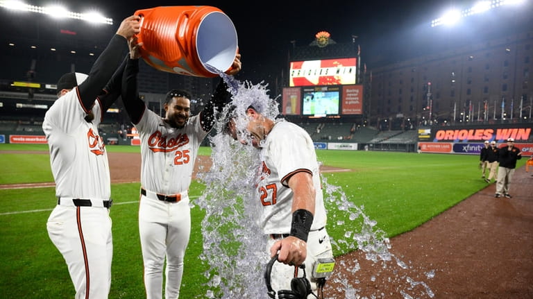 Baltimore Orioles' James McCann (27) gets doused by Anthony Santander...