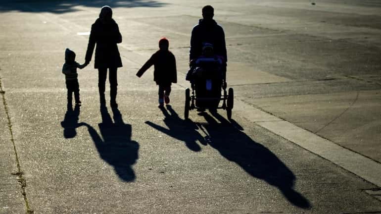Members of a refugee family from Syria cast long shadows...
