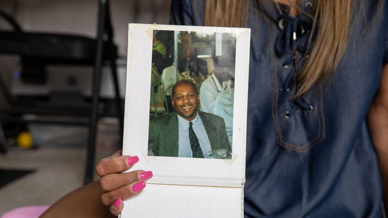 Kiesha Washington-Dean, of Riverhead, holds a photograph of her late...