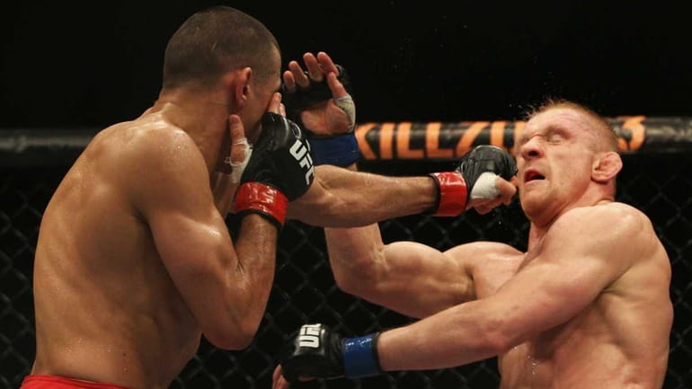 George Sotiropoulos of Australia punches Dennis Siver during their lightweight...
