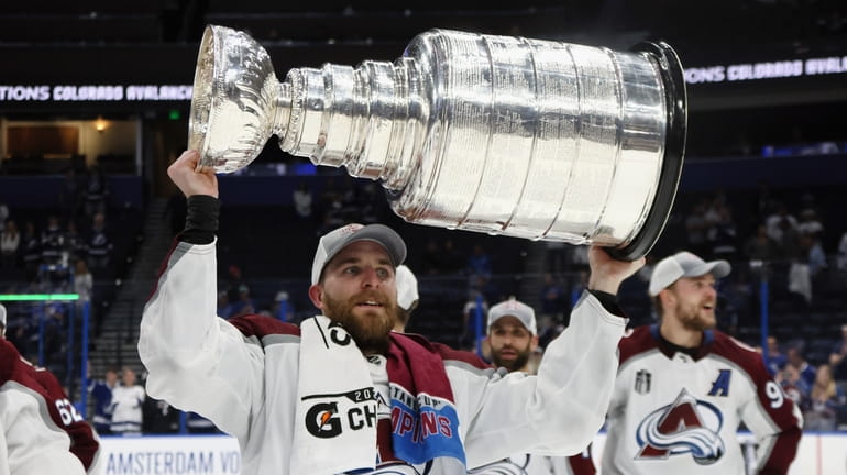 Devon Toews #7 of the Colorado Avalanche carries the Stanley...