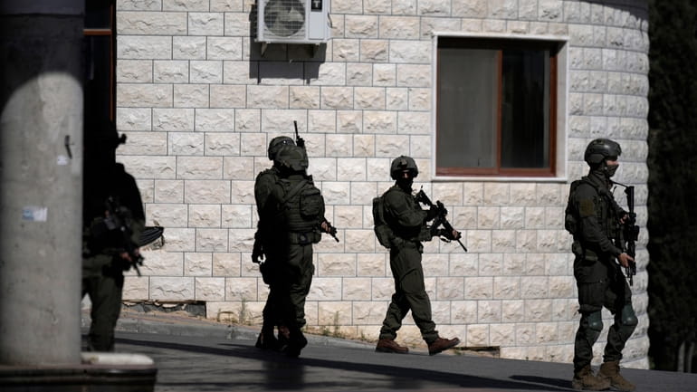 Israeli soldiers search in the West Bank village of Qafin...