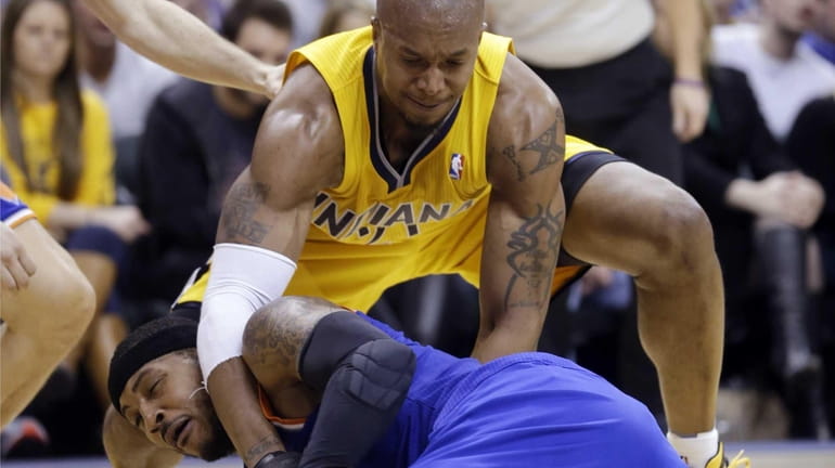 Indiana Pacers forward David West ties up Carmelo Anthony on...