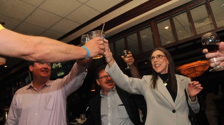 Carol Meschkow, of Plainview, right, leads a toast celebrating the...