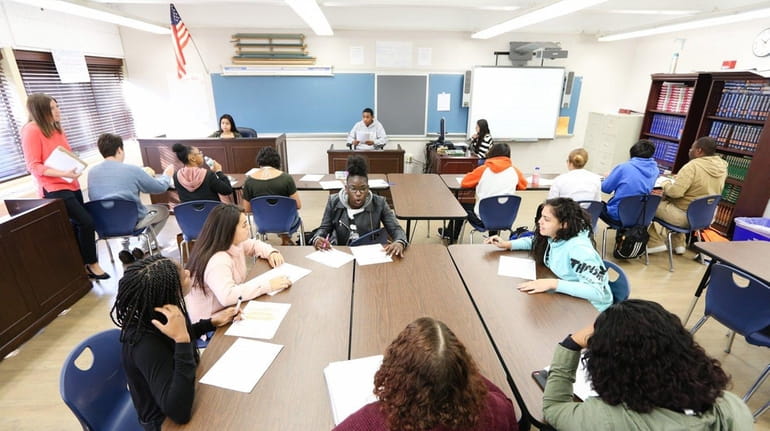 Students participate in a law and government class. The classroom...