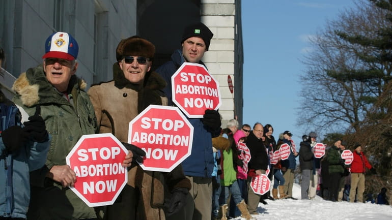 Participants in the annual anti-abortion rally surround the state house...