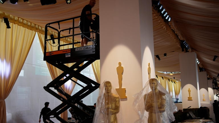 Workers prepare the Oscars red carpet ahead of the 96th...