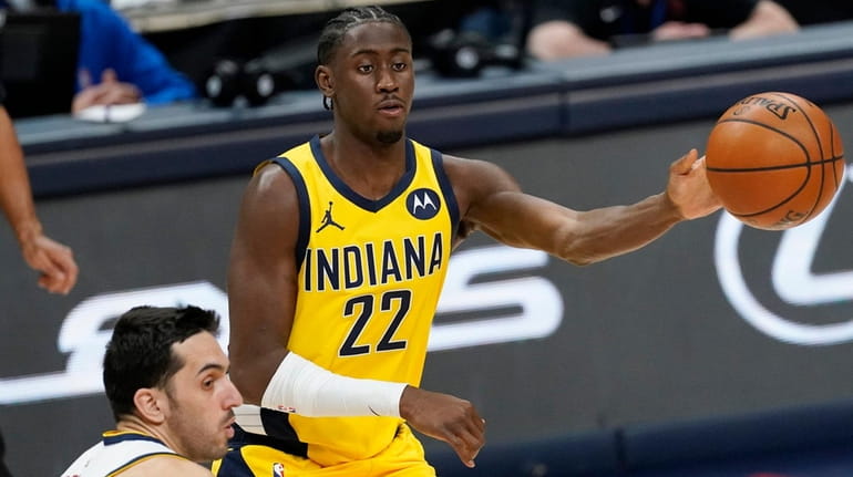Pacers guard Caris LeVert, back, passes the ball as Nuggets...