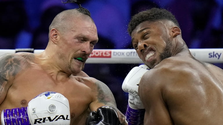 FILE - Britain's Anthony Joshua, right, takes a blow from...