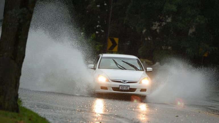 Cars drive through floodwater on Laurel Road in Northport on...