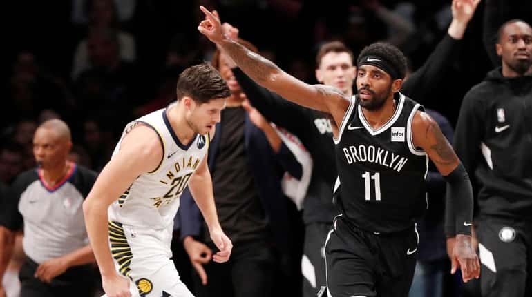 Nets guard Kyrie Irving gestures as he runs downcourt after...